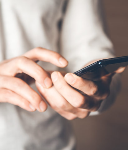 Person nutzt Smartphone, Fokus auf Hände und Bildschirm