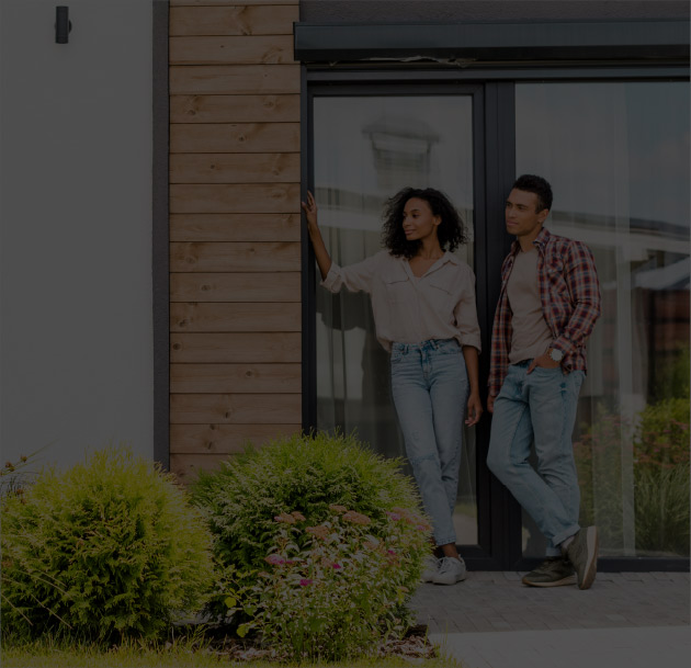 Zwei Personen vor modernem Haus mit Garten