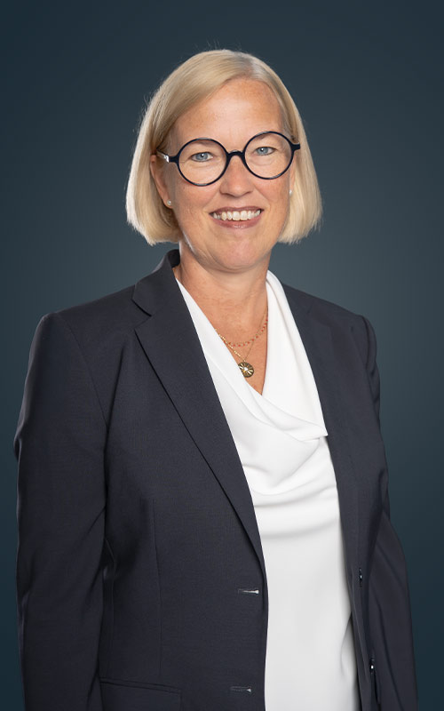 Portrait von Sandra Kautenburger vor dunkelblauem Hintergrund